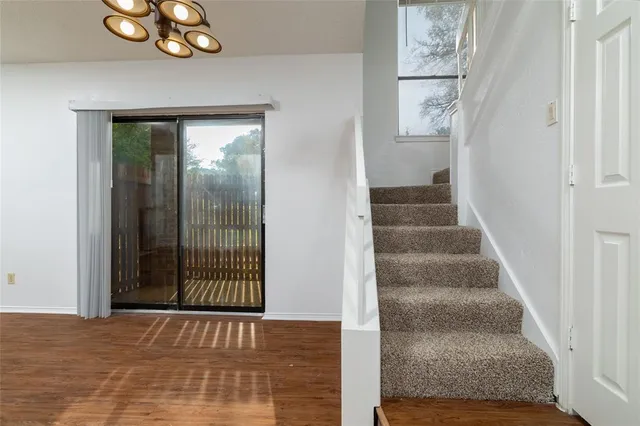 a view of a hallway with wooden floor and entryway