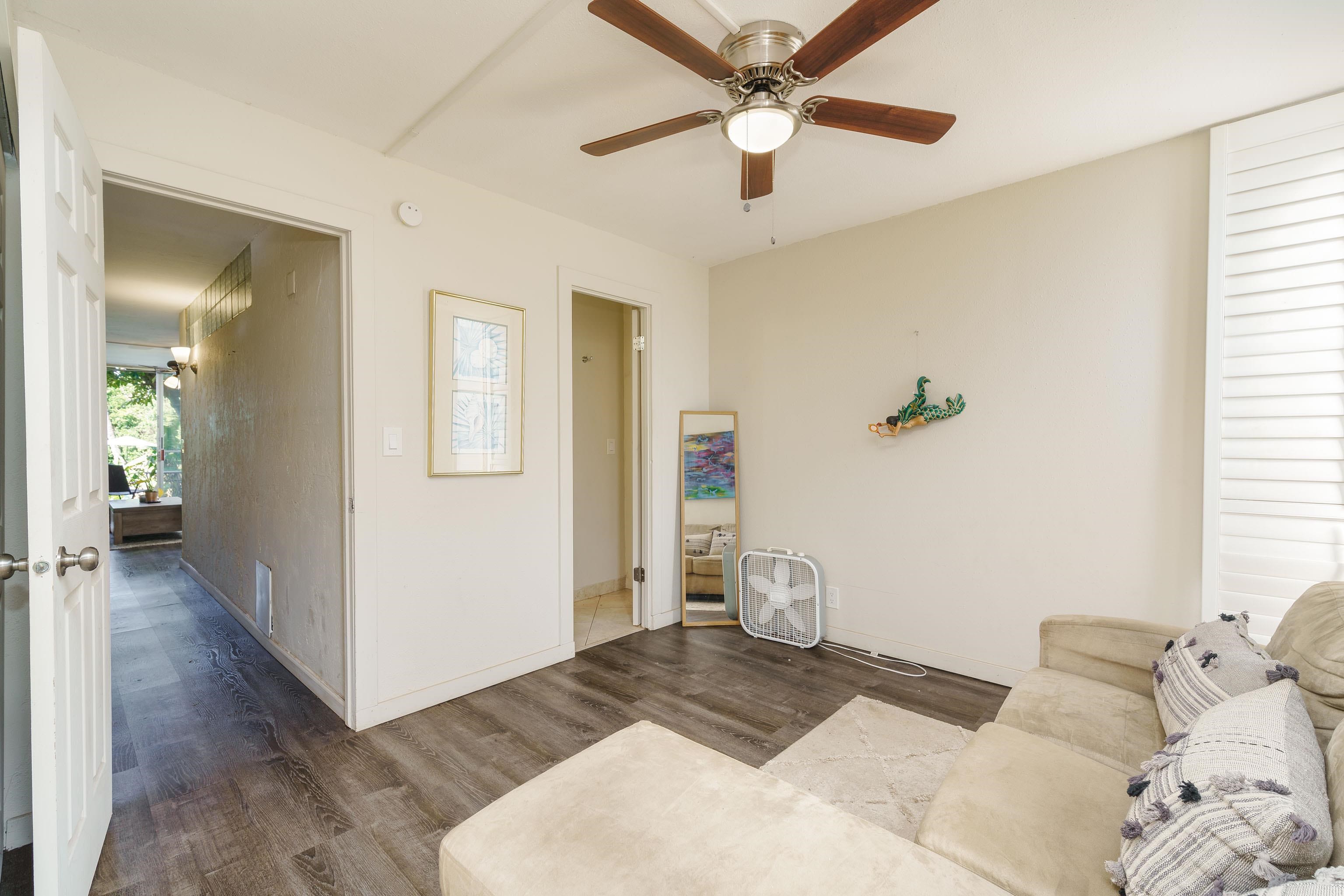 3660 Lower Honoapiilani Road, Unit 111 Lahaina, HI 96761 - Photo 16 of 28 a bedroom with a large bed and a chandelier fan