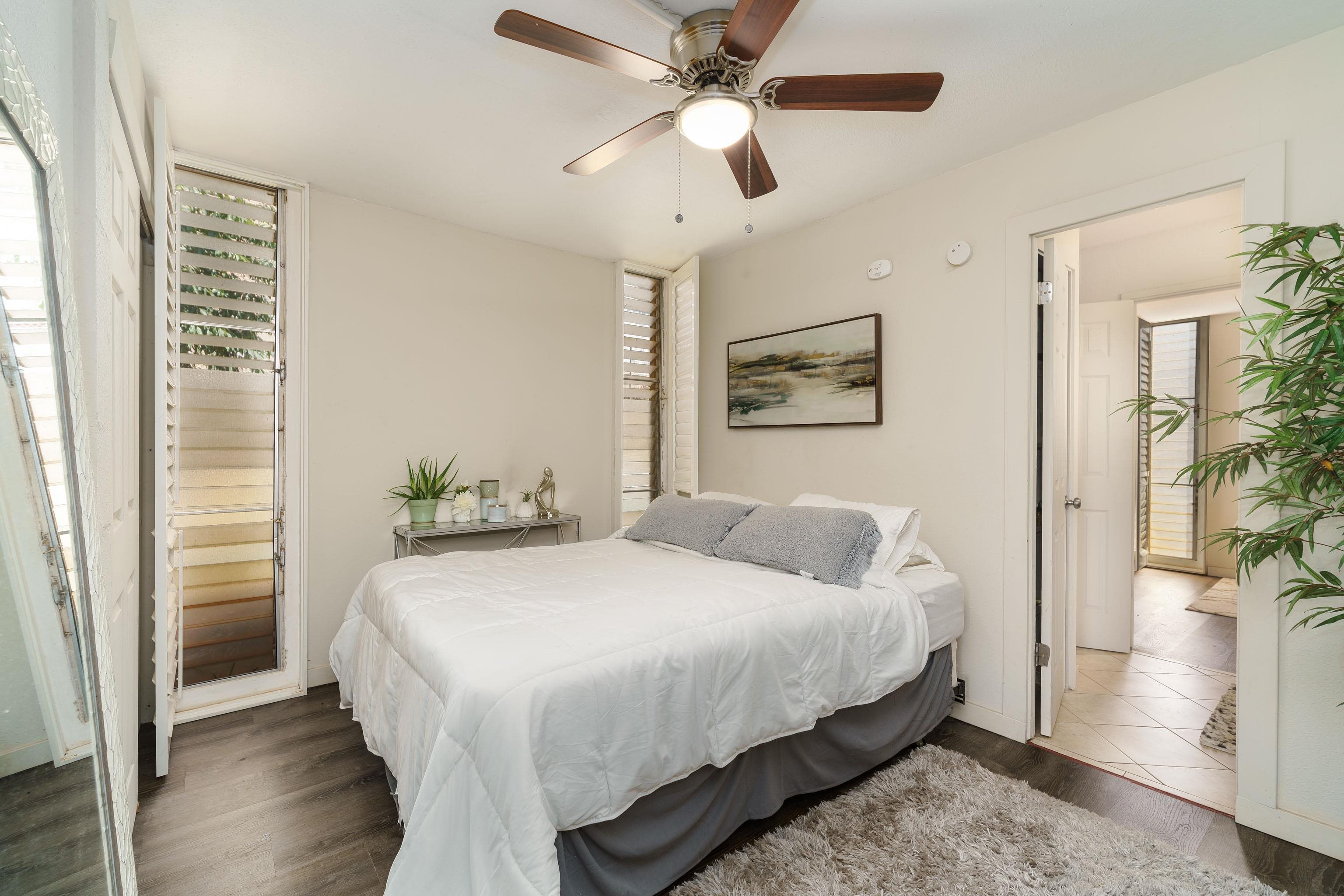 3660 Lower Honoapiilani Road, Unit 111 Lahaina, HI 96761 - Photo 9 of 28 a bedroom with a bed and a chandelier