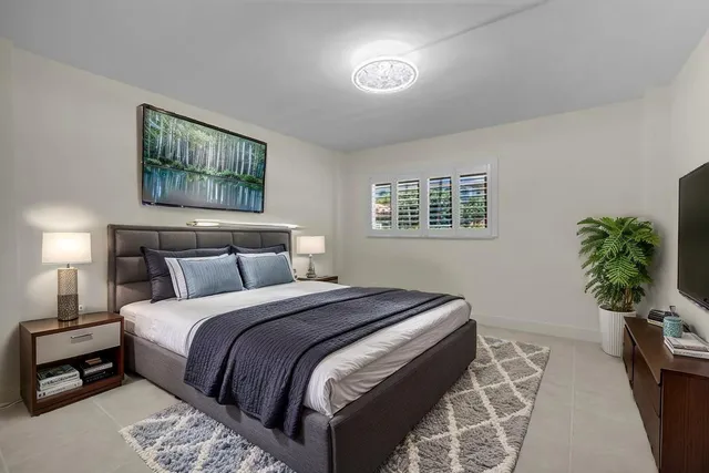 a bedroom with bed and a potted plant