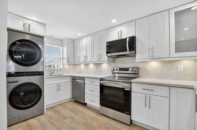 a kitchen with white cabinets and stainless steel appliances