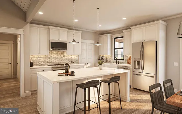 a kitchen with stainless steel appliances a refrigerator a sink a stove a kitchen island and chairs with wooden floor