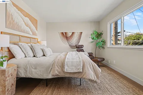 a bed sitting in a bedroom next to a window