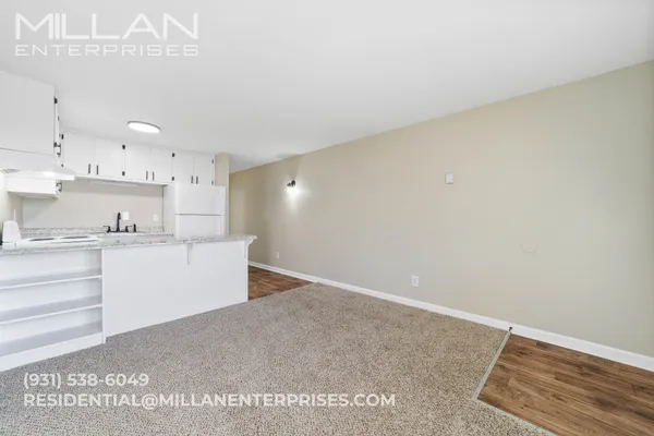 a view of kitchen with kitchen island microwave and cabinets