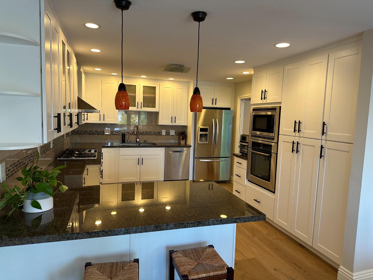 145 Calle Larga Los Gatos, CA 95032 - Photo 4 of 26 a kitchen with stainless steel appliances granite countertop a sink a stove and a refrigerator