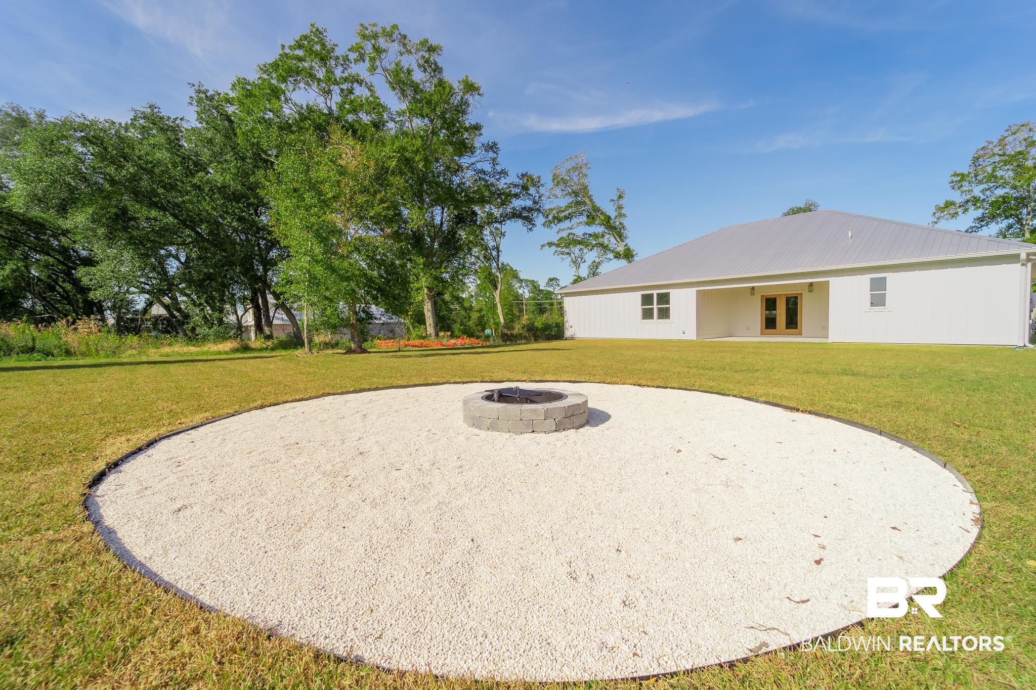 9263 Clarke Ridge Road Foley, AL 36535 - Photo 36 of 40 Exterior space featuring a fire pit and a lawn