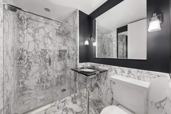 a bathroom with a sink toilet vanity and shower