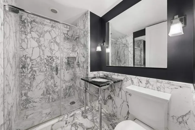 a bathroom with a sink toilet vanity and shower