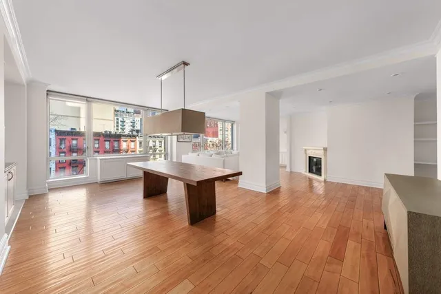 a kitchen with stainless steel appliances wooden floor and large windows