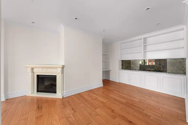 a view of empty room with wooden floor and fireplace