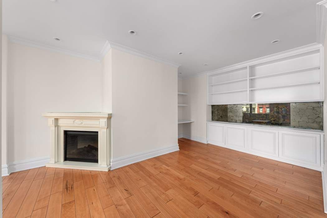 401 East 60th Street, Unit 4C Manhattan, NY 10022 - Photo 20 of 28 a view of empty room with wooden floor and fireplace