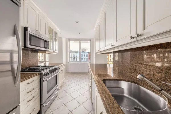 a kitchen with granite countertop a stove sink and cabinets