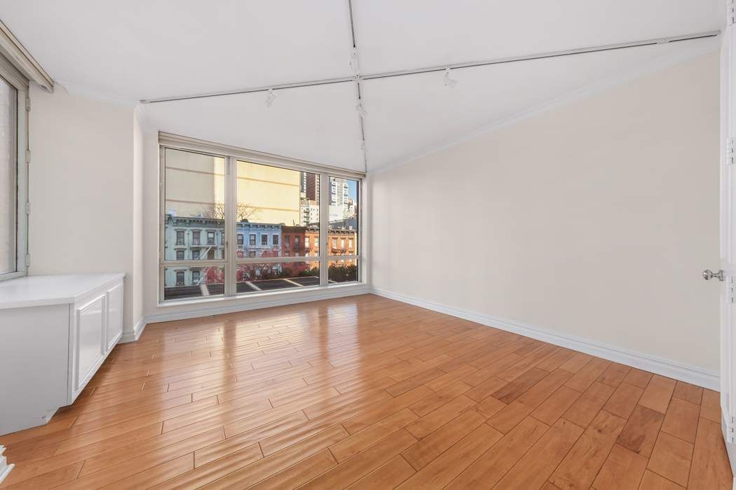401 East 60th Street, Unit 4C Manhattan, NY 10022 - Photo 26 of 28 a view of a room with wooden floor and fan