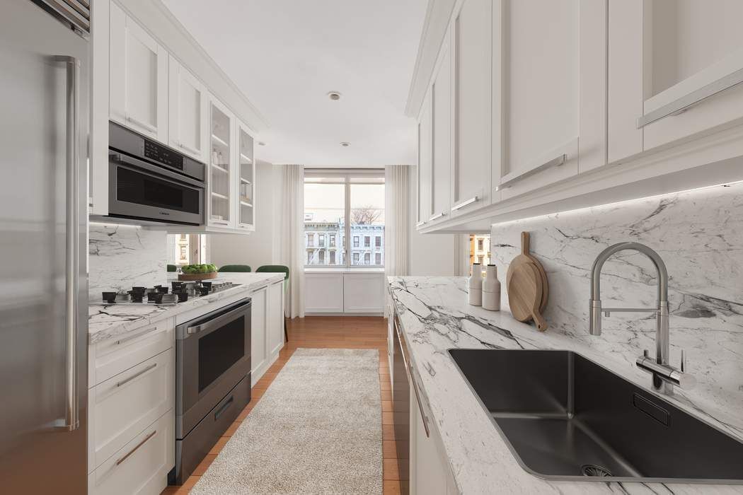 401 East 60th Street, Unit 4C Manhattan, NY 10022 - Photo 5 of 28 a kitchen with stainless steel appliances granite countertop a sink stove and microwave