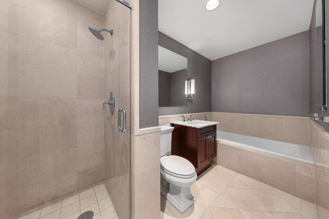 401 East 60th Street, Unit 4C Manhattan, NY 10022 - Photo 9 of 28 a bathroom with a toilet a sink and bathtub