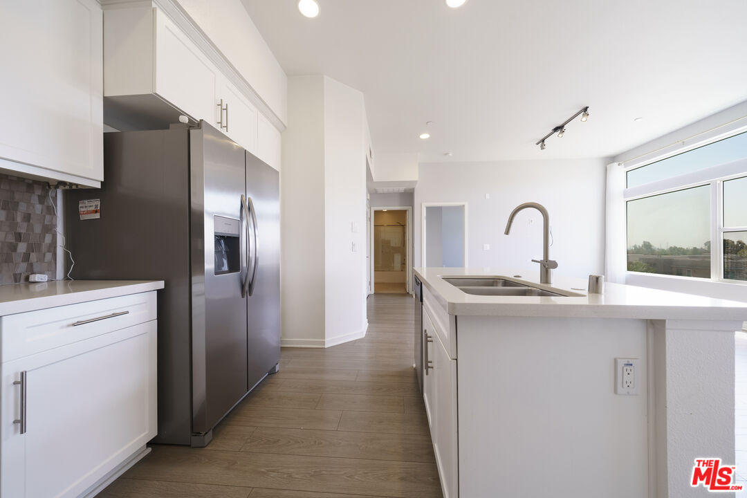 552 East Carson Street, Unit 408 Carson, CA 90745 - Photo 25 of 63 a kitchen with stainless steel appliances granite countertop a sink a refrigerator and cabinets
