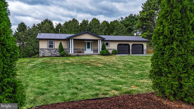 a view of a yard in front of a house with large windows