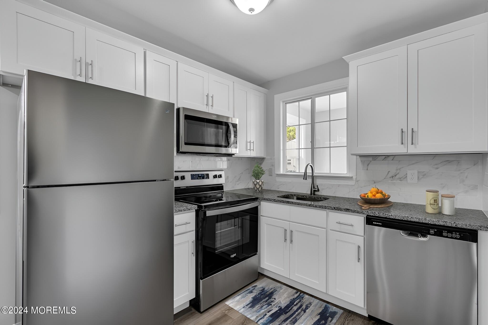 7 A Spring Street, Unit 50 Whiting, NJ 08759 - Photo 9 of 16 a kitchen with stainless steel appliances a refrigerator stove microwave and sink
