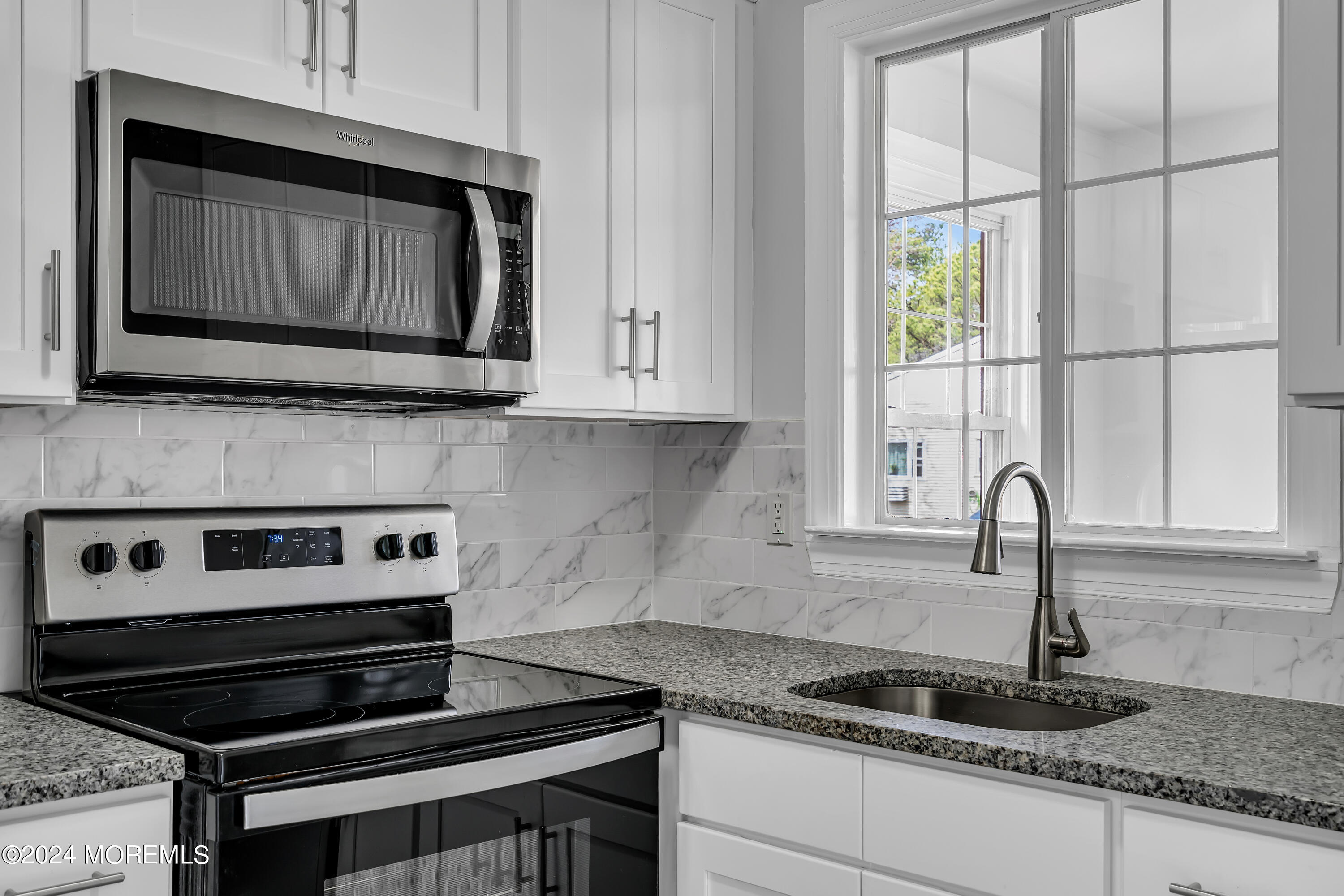 7 A Spring Street, Unit 50 Whiting, NJ 08759 - Photo 10 of 16 a kitchen with granite countertop a stove and a microwave