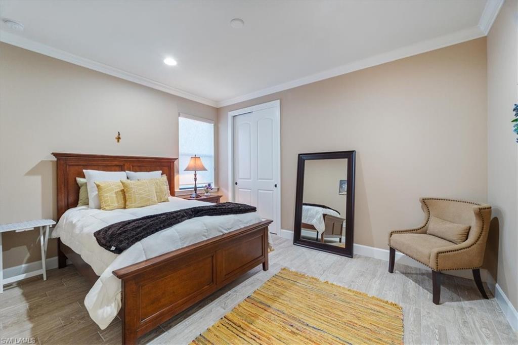 9418 Greyhawk Trail Naples, FL 34120 - Photo 11 of 34 a bedroom with a bed and chair