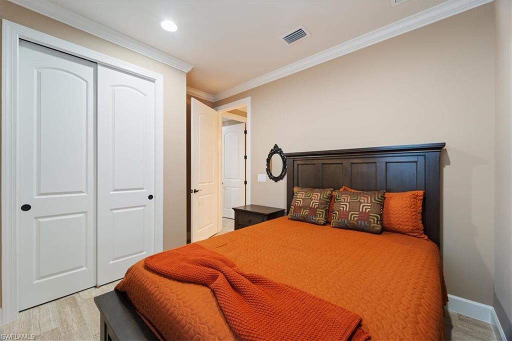 9418 Greyhawk Trail Naples, FL 34120 - Photo 13 of 34 a bedroom with a bed and wooden floor