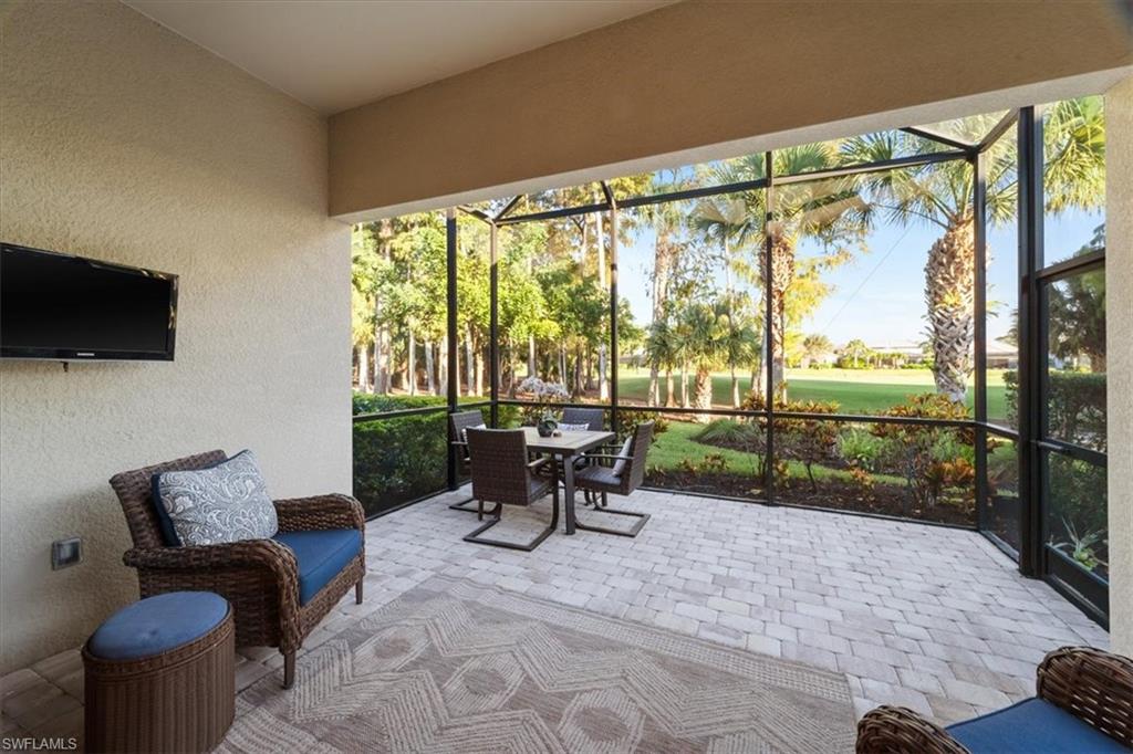 9418 Greyhawk Trail Naples, FL 34120 - Photo 19 of 34 a view of a patio with a table chairs and a flat screen tv
