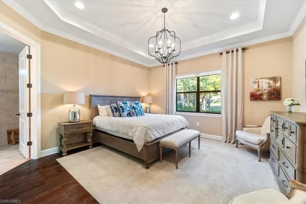 a spacious bedroom with a bed and a chandelier