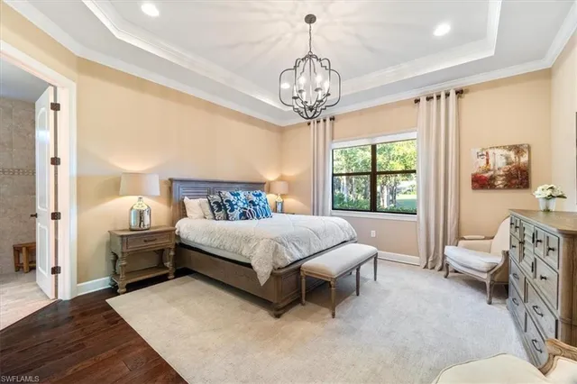 a spacious bedroom with a bed and a chandelier