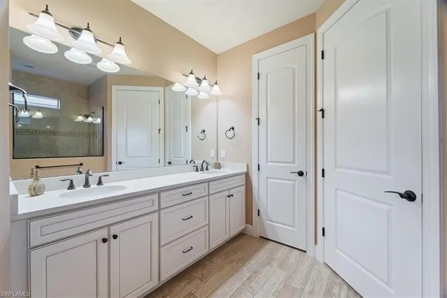 a spacious bathroom with a double vanity sink a large mirror a and a shower