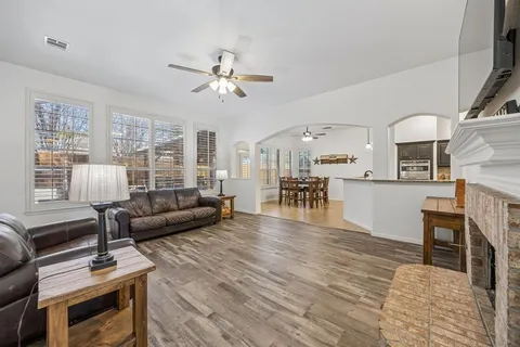 a living room with furniture and a wooden floor