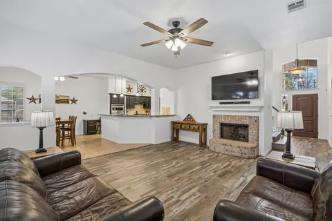 a living room with furniture a fireplace and a flat screen tv