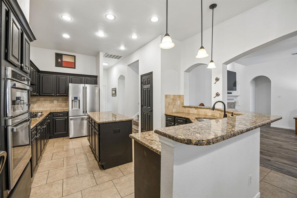5 Cimarron Court Trophy Club, TX 76262 - Photo 19 of 30 a large kitchen with stainless steel appliances granite countertop a sink a stove and a refrigerator
