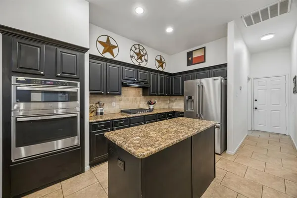 a kitchen with stainless steel appliances granite countertop a refrigerator stove and sink