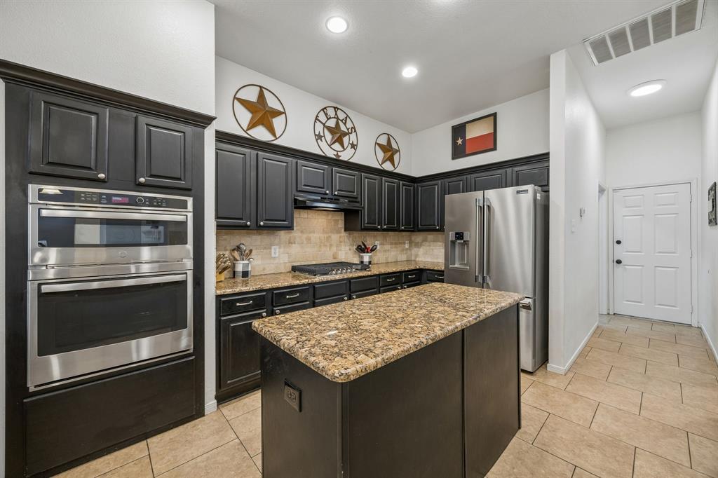 5 Cimarron Court Trophy Club, TX 76262 - Photo 20 of 30 a kitchen with stainless steel appliances granite countertop a refrigerator stove and sink