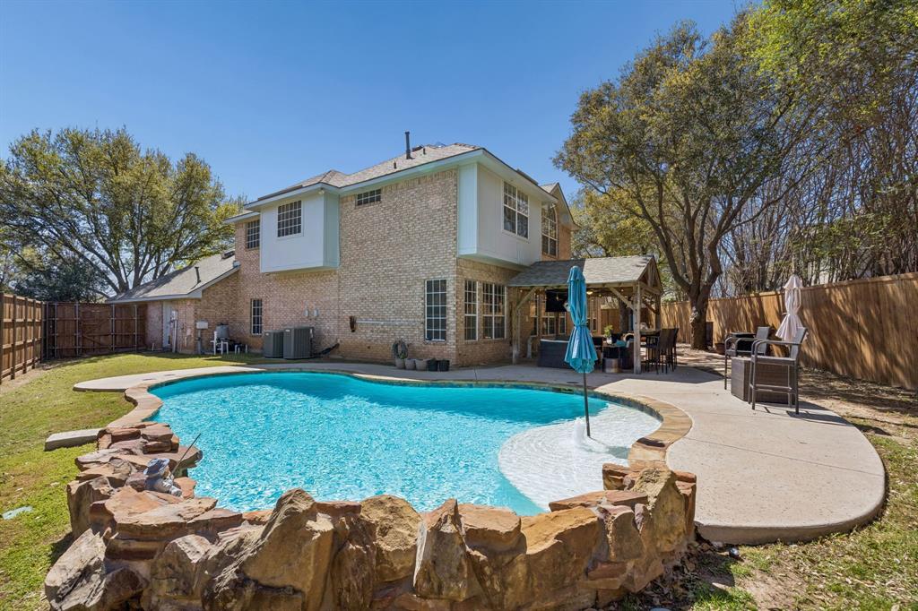 5 Cimarron Court Trophy Club, TX 76262 - Photo 2 of 30 a view of a backyard with table and chairs potted plants and a large tree