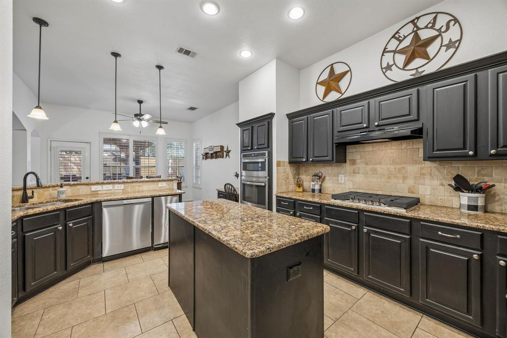 5 Cimarron Court Trophy Club, TX 76262 - Photo 21 of 30 a kitchen with granite countertop stainless steel appliances and wooden cabinets
