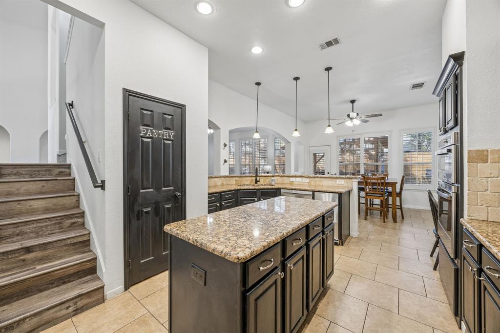 5 Cimarron Court Trophy Club, TX 76262 - Photo 22 of 30 a kitchen with stainless steel appliances granite countertop furniture and a chandelier