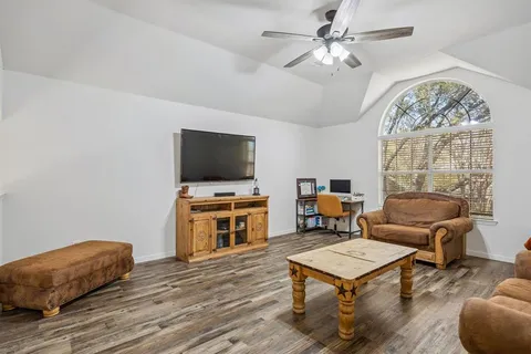 a living room with furniture a chandelier and a flat screen tv