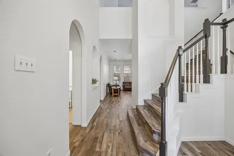 a view of a hallway with wooden floor and staircase