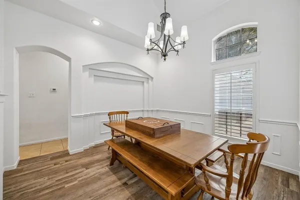a room with chandelier table and windows