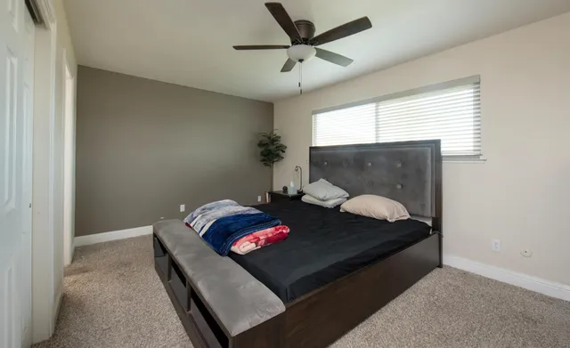 a bed sitting in a bedroom next to a window