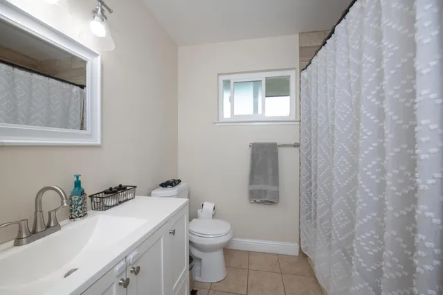 a bathroom with a toilet sink vanity and mirror
