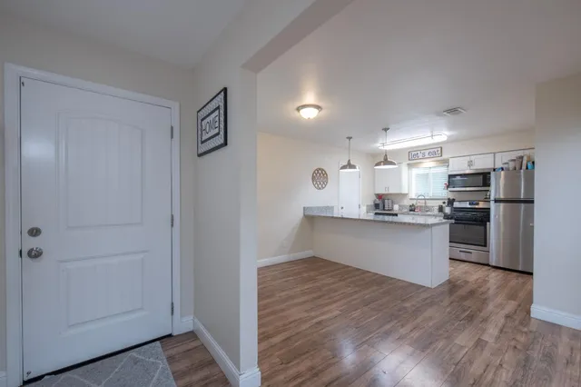 a kitchen with stainless steel appliances kitchen island wooden cabinets and refrigerator