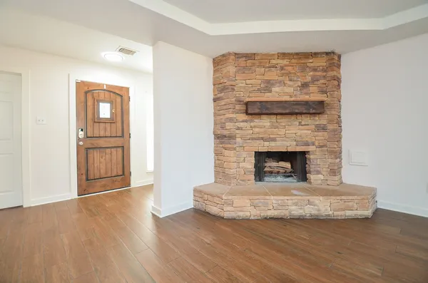 a living room with a fireplace and wooden floor