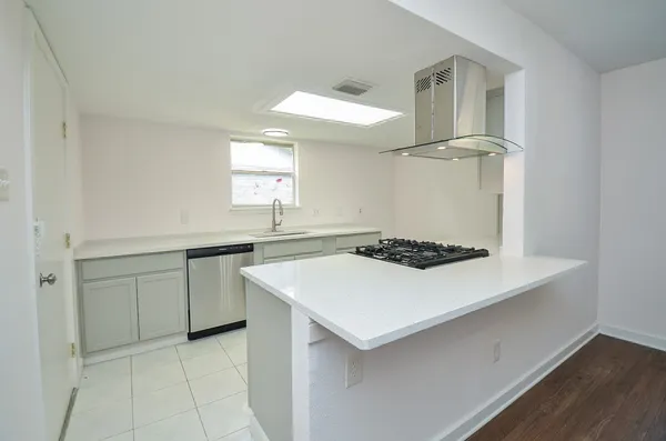 a kitchen with a sink a stove cabinets and wooden floor