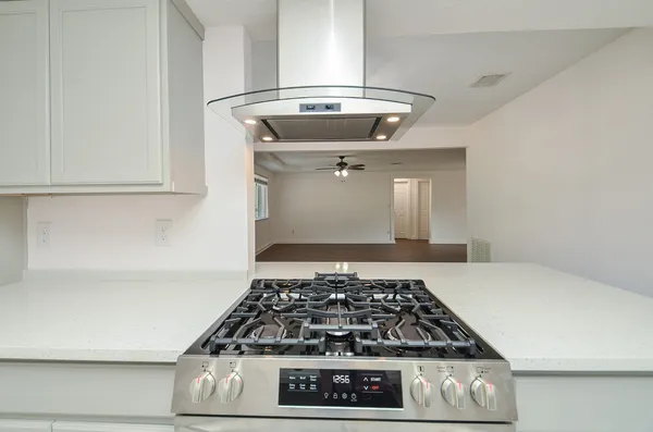 a kitchen with a stove and white cabinets