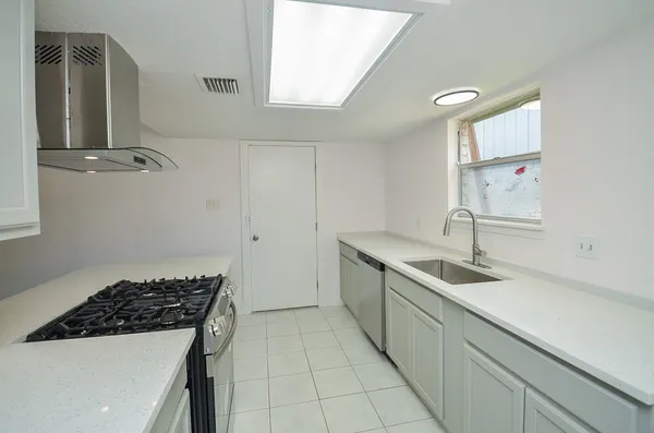 a kitchen with a sink stove and cabinets