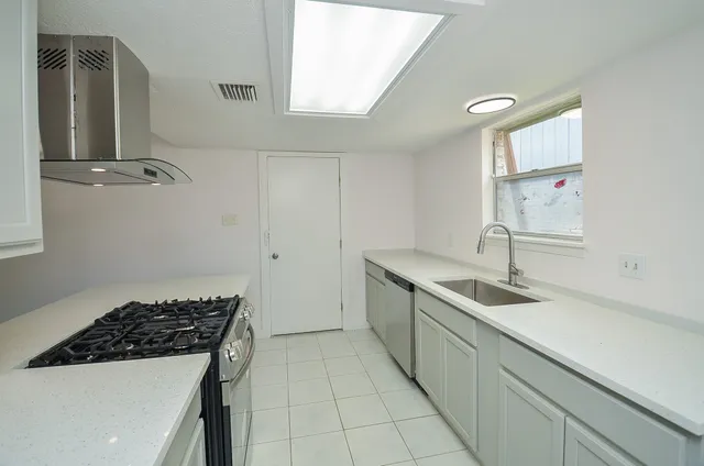 a kitchen with a sink stove and cabinets