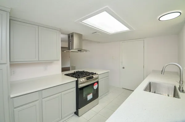 a kitchen with stainless steel appliances granite countertop a sink stove and cabinets