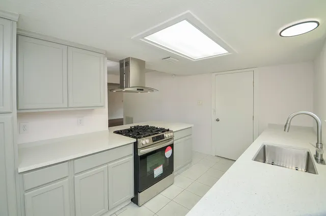 a kitchen with stainless steel appliances granite countertop a sink stove and cabinets